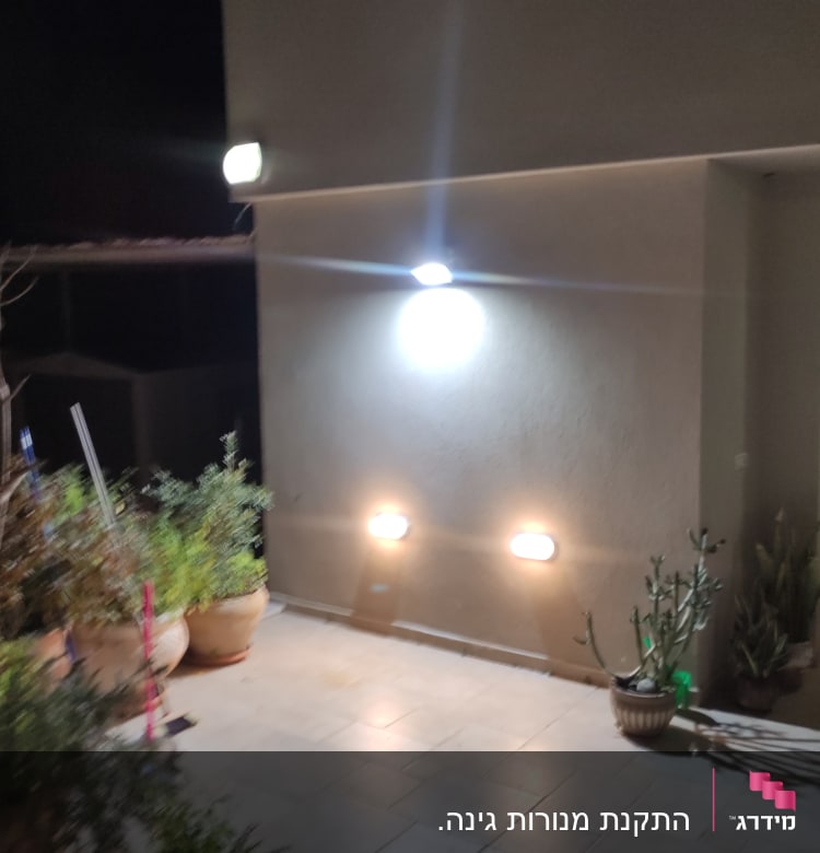 תאורה חיצונית על קיר בית בלילה